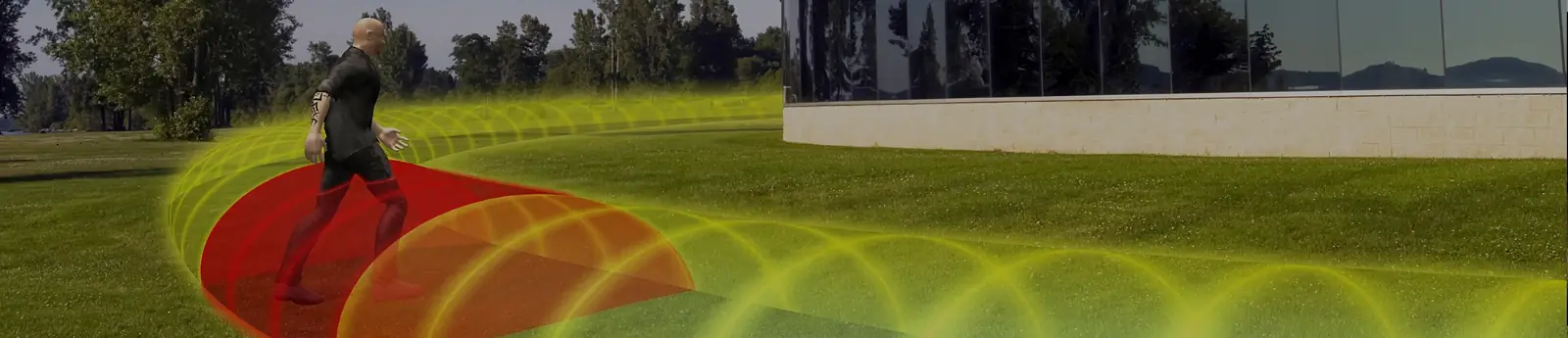 Visualisierung: Person läuft über eine Rasenfläche vor einem Gebäude durch die Mikrowellen-Detektionszone; der Bereich um die Person ist rot markiert – Visualisierung Southwest Microwave (Symbolbild): Mikrowellendetektion.