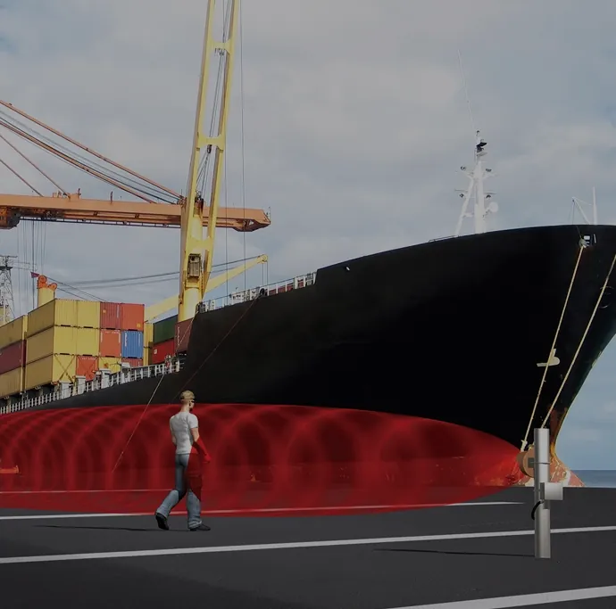 Visualisierung Southwest Microwave: Person geht im Hafen an einem Containerschiff durch eine rot markierte Mikrowellenzone – Southwest Microwave: Zaun-, Mikrowellen- und Hafenanwendungen (Visualisierung).