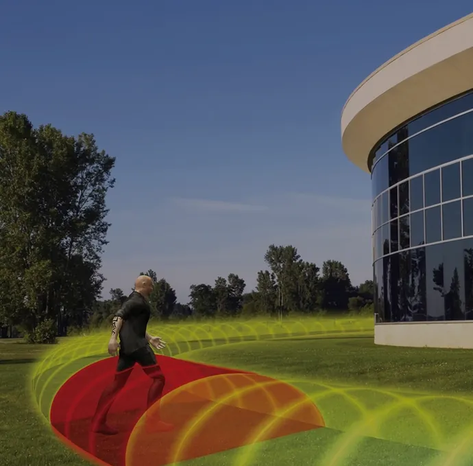 Visualisierung Southwest Microwave: Person läuft durch eine Mikrowellen-Detektionszone vor einem Gebäude – Southwest Microwave: Zaun-, Mikrowellen- und Hafenanwendungen (Visualisierung).
